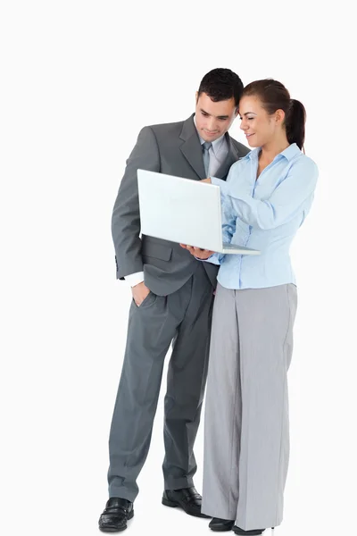 Zakenpartner op zoek naar een laptop tegen een witte achtergrond — Stockfoto
