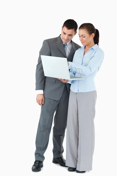 Üzleti partner látszó-on egy notebook, egy fehér háttér mintázata ellen — Stock Fotó