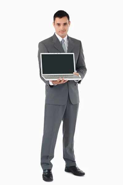 Empresário apresentando seu laptop contra um fundo branco — Fotografia de Stock