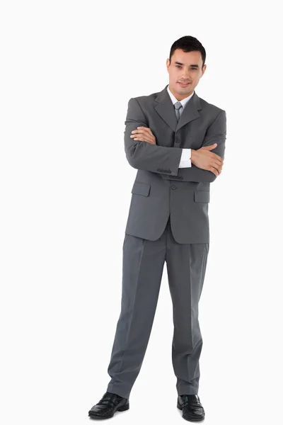 Empresário com braços dobrados contra um fundo branco — Fotografia de Stock