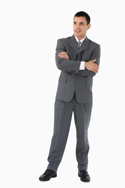 Empresário com braços dobrados olhando confiante contra um b branco — Fotografia de Stock