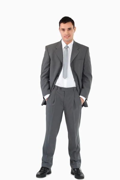 Бизнесмен с руками в карманах против белого бэкгра — стоковое фото