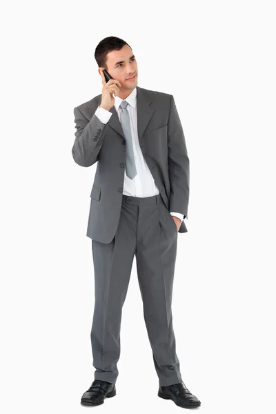 Geschäftsmann hört Anruferin vor weißem Hintergrund zu — Stockfoto