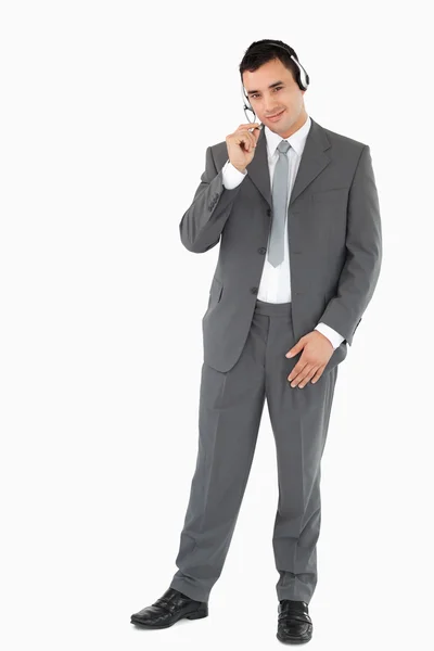 Affärsman med hörlurarna på mot en vit bakgrund — Stockfoto