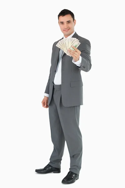 Uśmiechający się biznesmen prezentuje banknoty — Zdjęcie stockowe