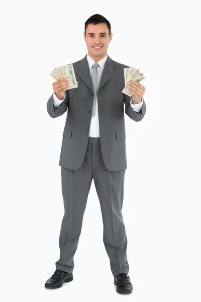 Uomo d'affari che presenta le banconote con entrambe le mani — Foto Stock