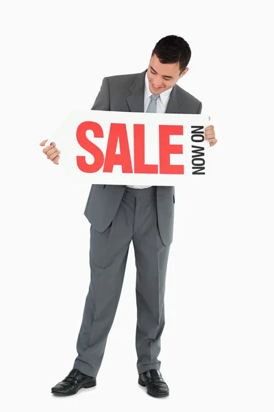 Businessman looking at signboard in his hands — Stock Photo, Image