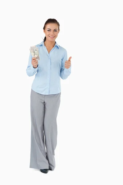 Glimlachende zakenvrouw met bankbiljetten duim opgevend — Stockfoto