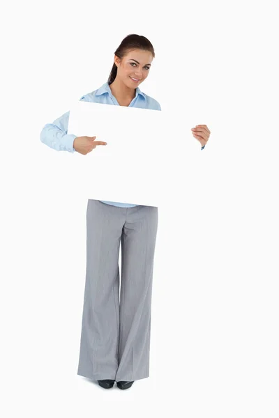 Businesswoman pointing at the sign she is presenting — Stock Photo, Image