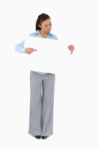 Young businesswoman looking at the sign she is presenting — Stock Photo, Image
