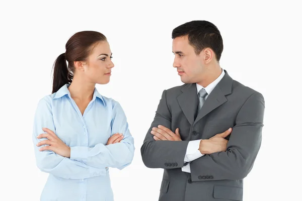 Serious business partners with arms folded looking at each other — Stock Photo, Image