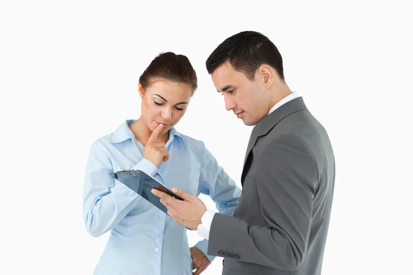 Business partners analyzing document on the clipboard — Stock Photo, Image