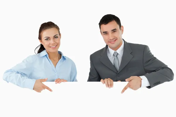 Business partners pointing at sign they are holding — Stock Photo, Image