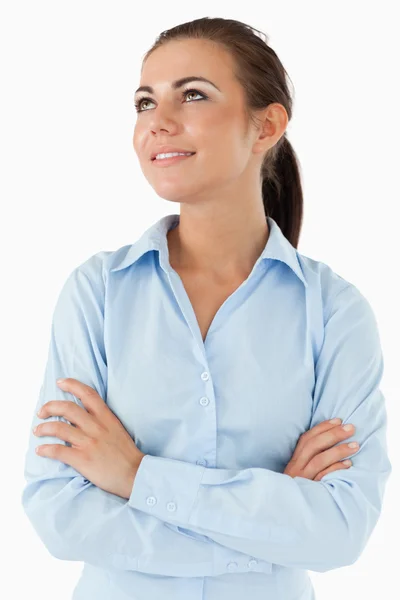 Businesswoman looking diagonally upwards with arms folded — Stock Photo, Image