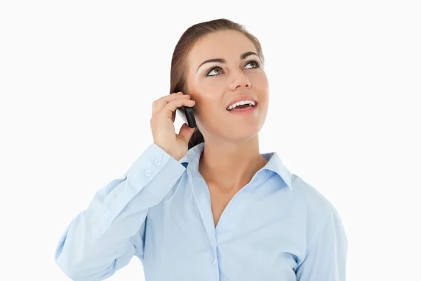 Lächelnde Geschäftsfrau blickt am Telefon nach oben — Stockfoto
