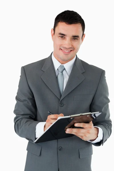 Un hombre de negocios sonriente tomando notas —  Fotos de Stock