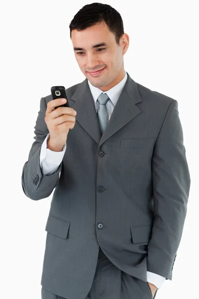 Leende affärsman titta på hans mobiltelefon — Stockfoto