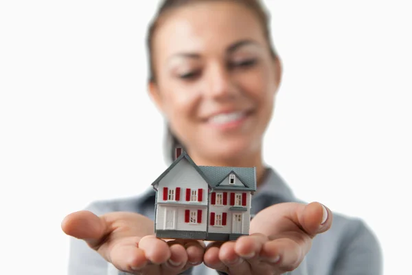 Close up of miniature house being held by female estate agent — Stock Photo, Image