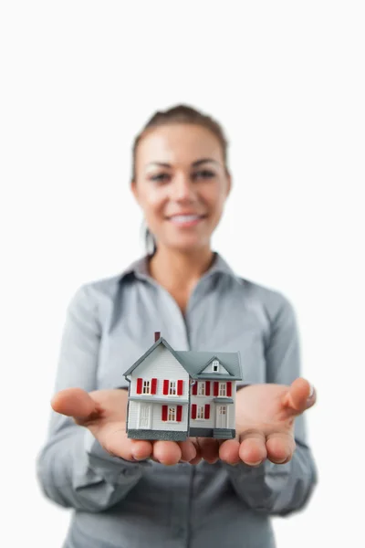 Miniature house being presented by young female estate agent — Stock Photo, Image