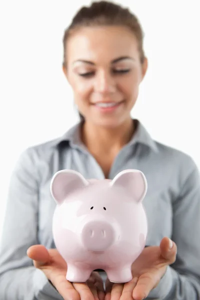 Close up van piggy bank vastgehouden door vrouwelijke bank assistent — Stockfoto
