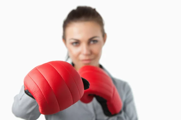 Boxing gloves used to slam by young businesswoman — Stock Photo, Image