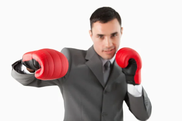 Primer plano del hombre de negocios con guantes de boxeo golpeando un gancho —  Fotos de Stock