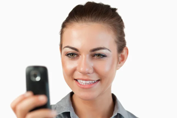Close up of smiling businesswoman reading a text message — Stock Photo, Image