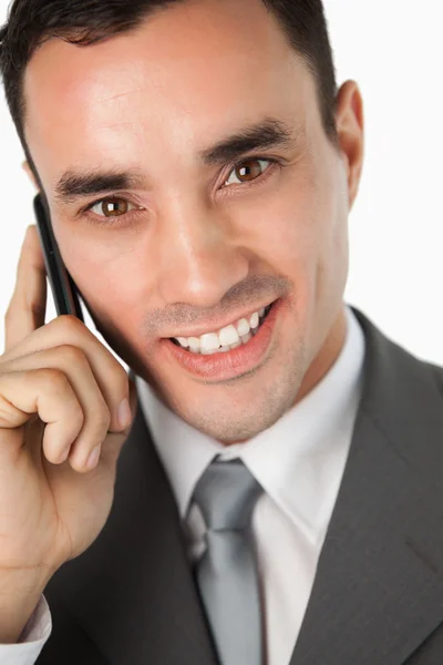 Close up van lachende jonge zakenman aan de telefoon — Stockfoto