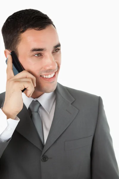 Close up of smiling businessman looking to the side while on the — Stock Photo, Image