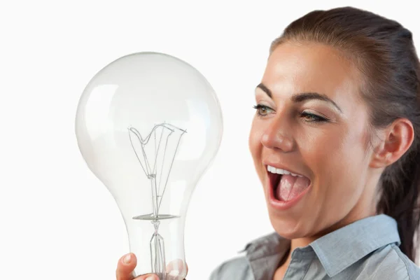 Крупним планом бізнес-леді дивується величезною лампочкою — стокове фото