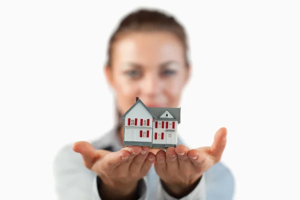 Casa en miniatura mostrada por agente inmobiliaria femenina — Foto de Stock