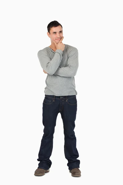 Jovem do sexo masculino de pé e pensamento — Fotografia de Stock