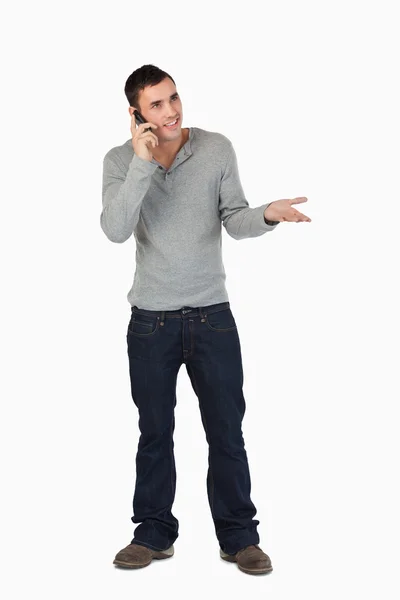 在电话上年轻男性打手势时 — 图库照片