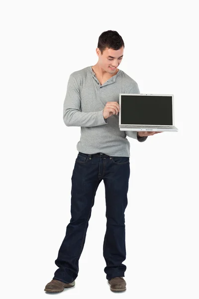 Mladý muž, ukazující jeho laptop — Stock fotografie