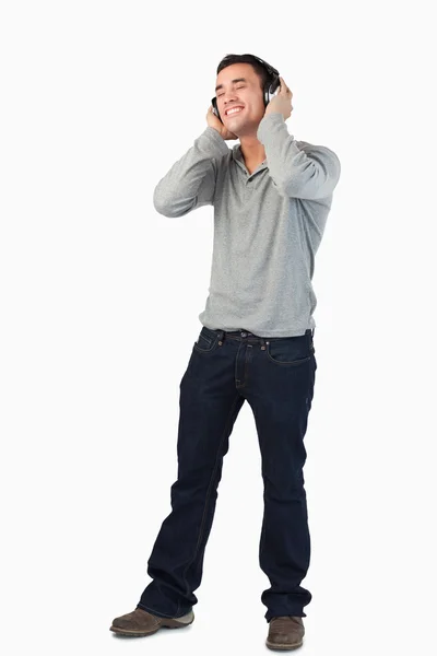 Jonge man luisteren naar muziek met koptelefoon op — Stockfoto