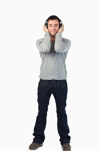 Jonge man genieten van muziek met koptelefoon op — Stockfoto