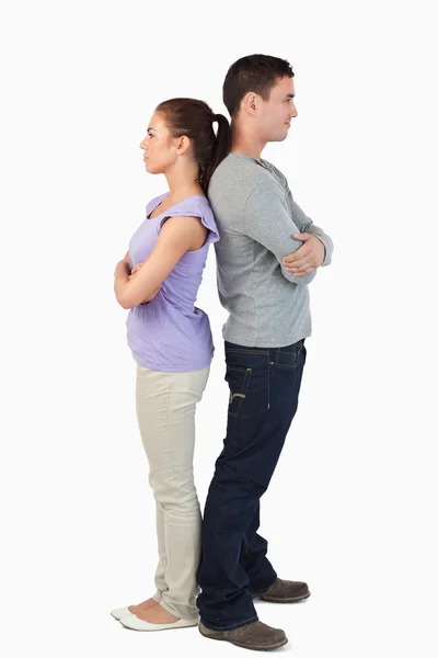 Young couple standing back-to-back — Stock Photo, Image