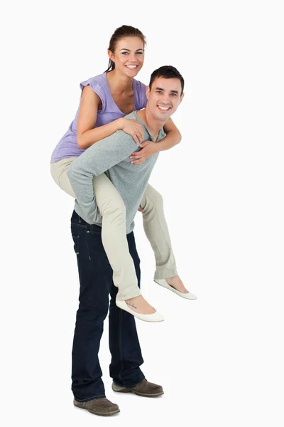 Ung man bär hans flickvän piggyback — Stockfoto