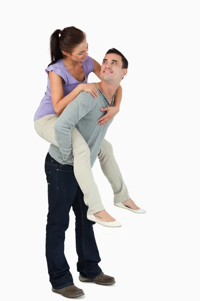 Unga kvinnliga piggyback som hennes pojkvän — Stockfoto