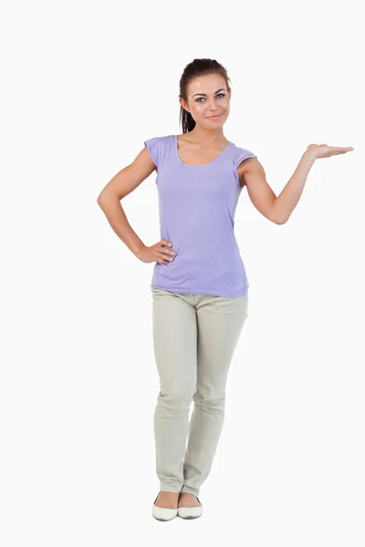 Junge Frau präsentiert mit erhobener Handfläche — Stockfoto