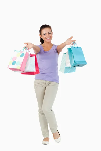 Feliz joven mujer presentando sus bolsas de compras — Foto de Stock