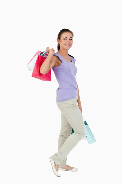 Vista lateral da jovem fêmea com compras — Fotografia de Stock