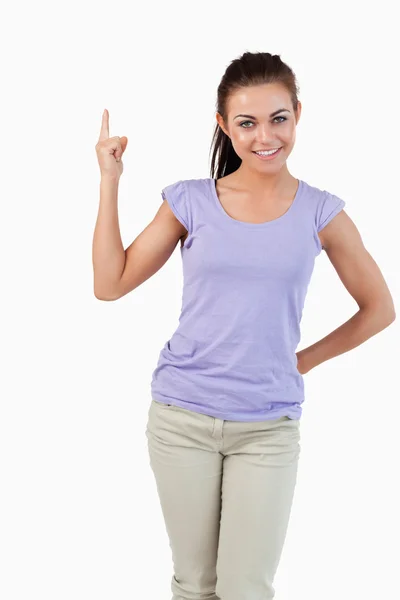 Unga kvinnliga pekar uppåt medan leende — Stockfoto