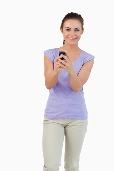 Sonriendo joven hembra sosteniendo su teléfono celular —  Fotos de Stock