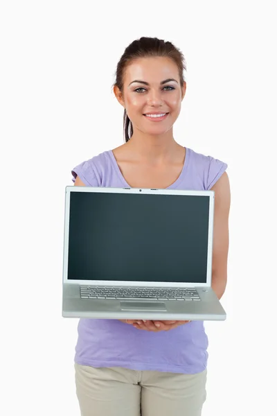 Sorrindo jovem fêmea mostrando seu laptop — Fotografia de Stock