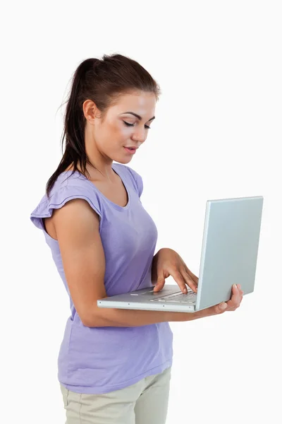 Ung kvinna skriver på sin laptop — Stockfoto