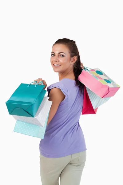 Visão traseira da jovem fêmea com sacos de compras — Fotografia de Stock
