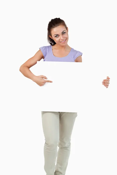 Young female pointing at banner in her hands — Stock Photo, Image