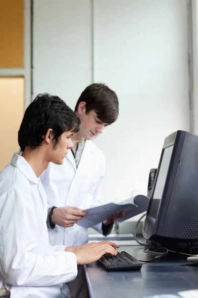 Male scientists using a monitor Stock Image