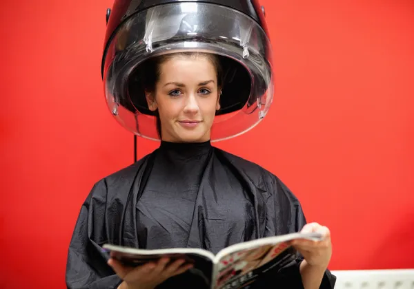 Young woman under a hairdressing machine Royalty Free Stock Photos
